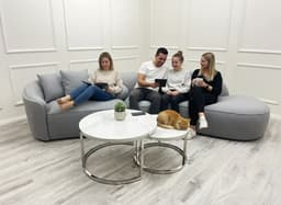 people in a living room sitting on a cinema-style sofa