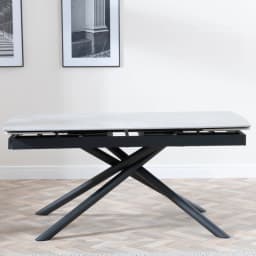 a grey top extendable dining table with black crossed legs