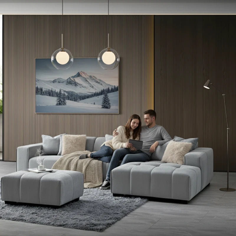 a couple sitting on a right-hand corner sofa looking at a tablet