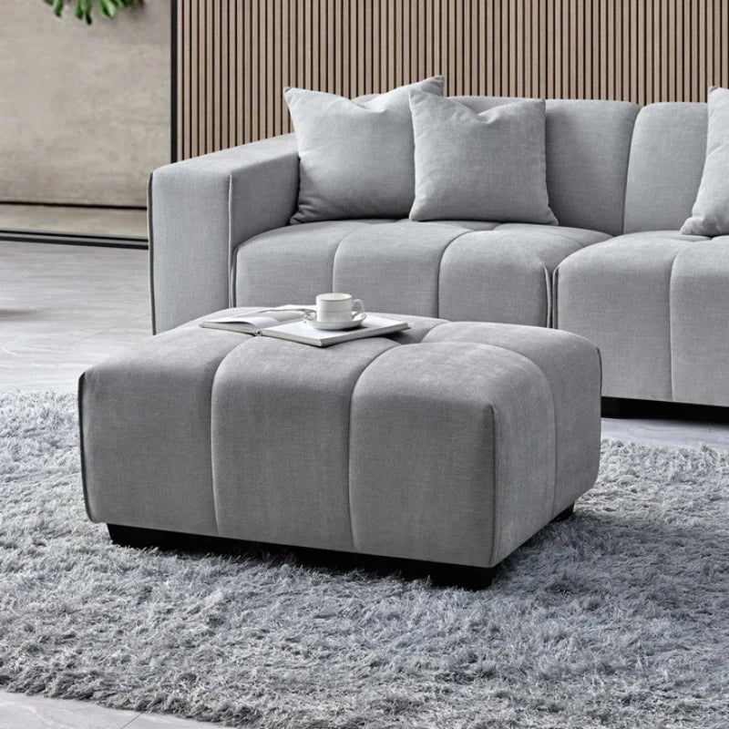 right corner sofa left end with a footstool and coffee on it.