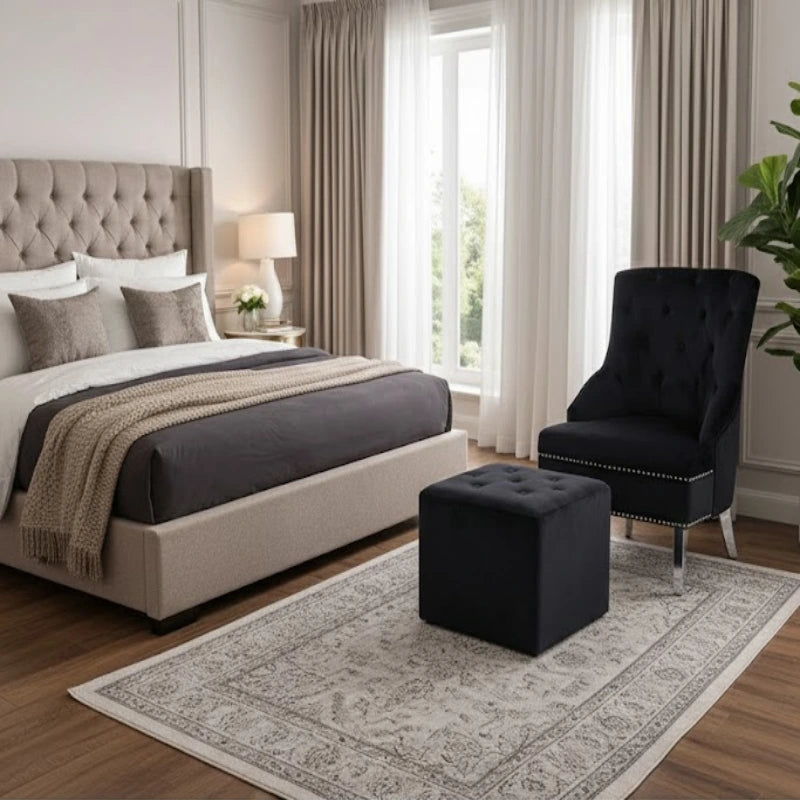 a bedroom with a comfort chair and stool